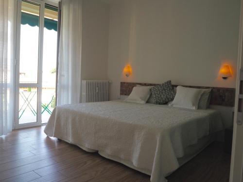 1 dormitorio con 1 cama con sábanas blancas y ventana en Suite Home Sophie en Verona