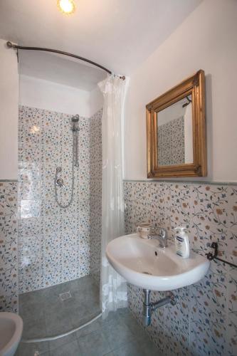 a bathroom with a sink and a shower with a mirror at Trulli La Zisa in Fasano