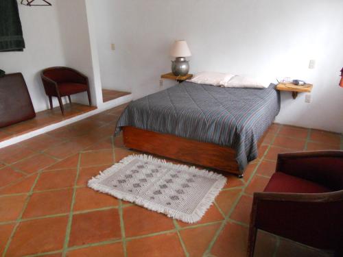 a bedroom with a bed and a table and chairs at Ollin Calli Hostal-Temazcal in Tepoztlán