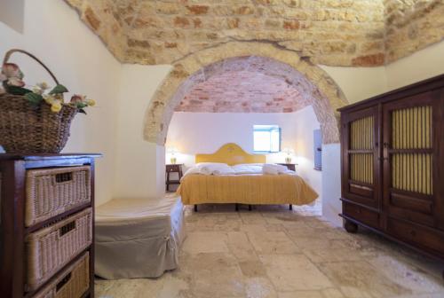 a bedroom with a bed and a brick wall at Trulli La Zisa in Fasano