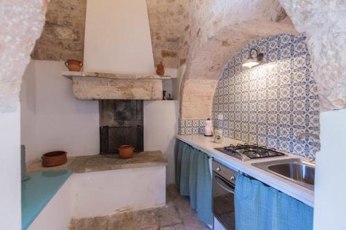a kitchen with a sink and a stove top oven at Trulli La Zisa in Fasano