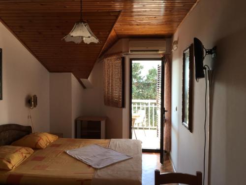 a bedroom with a bed with a wooden ceiling at Apartments Upitnik in Herceg-Novi