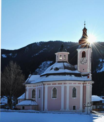 a building with a clock tower in the snow at Brunnerhof in Strassen