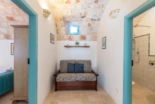 a bathroom with a chair in a hallway with a shower at Trulli La Zisa in Fasano