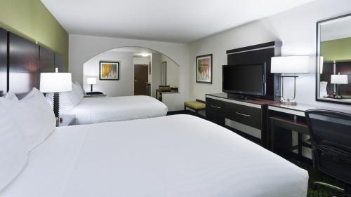 a hotel room with two beds and a flat screen tv at Holiday Inn Express and Suites Stroudsburg-Poconos by IHG in Stroudsburg