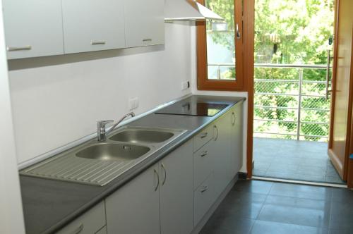 a white kitchen with a sink and a window at Villa Camp in Jurata