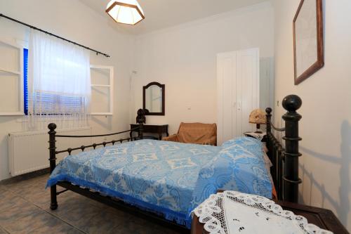 a bedroom with a bed with a blue comforter at Aristeides - Moscha Apartments in Platis Yialos Sifnos