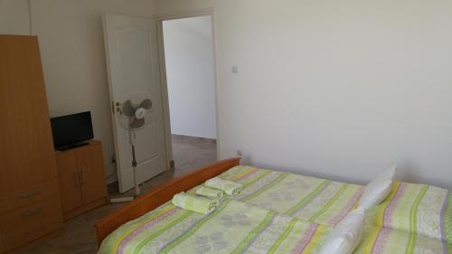 a bedroom with a bed with two towels on it at Vasti Apartman in Siófok
