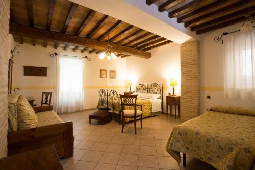 1 dormitorio con 2 camas, mesa y sillas en Hotel Palazzo Brunamonti, en Bevagna