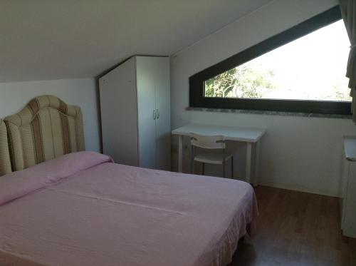 a bedroom with a bed and a desk and a window at Appartamenti Villa Abbraccio in Siena