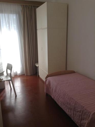 a bedroom with a bed and a chair and a window at Appartamenti Villa Abbraccio in Siena