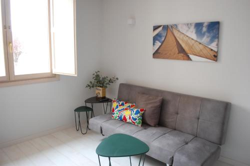a living room with a couch and two stools at Apartamentos La Harinera in Torres de Albarracín