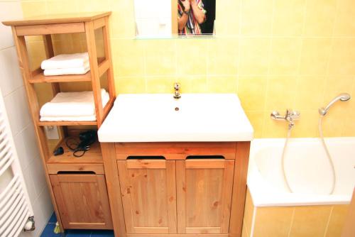 a bathroom with a white sink and a bath tub at Apartmán U krále - 2 in Jičín