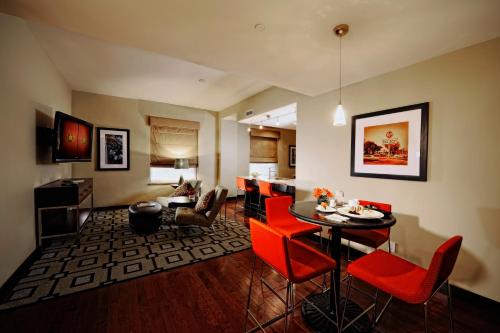 a living room with a table and red chairs at The Mayo Hotel in Tulsa
