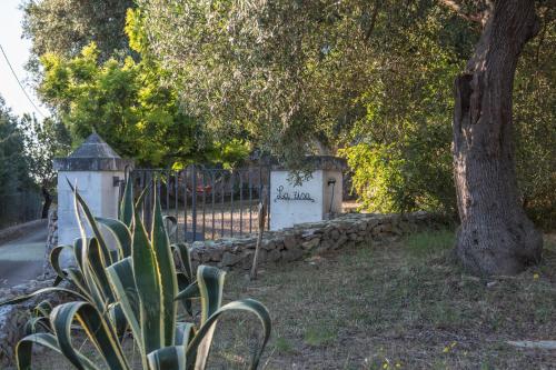 a gate with a stone wall next to a tree at Trulli La Zisa in Fasano