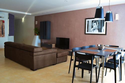 a living room with a couch and a dining room table at Hepburn Holiday Apartment in Birżebbuġa