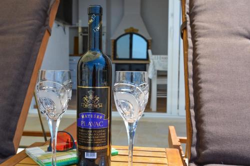 een fles wijn zittend op een tafel met twee glazen bij Apartment and room Sveti Jakov in Dubrovnik