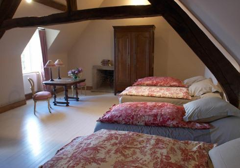 a bedroom with two beds and a table in a room at Les Galets Blancs in Le Conquet