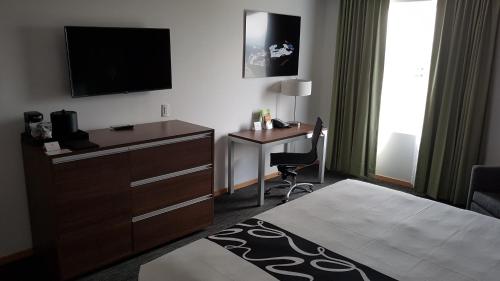 a hotel room with a bed and a desk with a television at La Quinta by Wyndham San Jose Chiapa Puebla in San José Chiapa