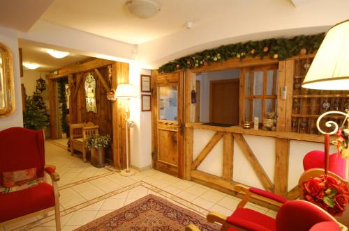 un soggiorno con pareti in legno e sedie rosse di Chalet Fiocco Di Neve a Pinzolo