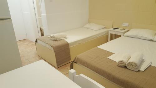 a room with two beds with towels on them at Enalio Rooms in Glida
