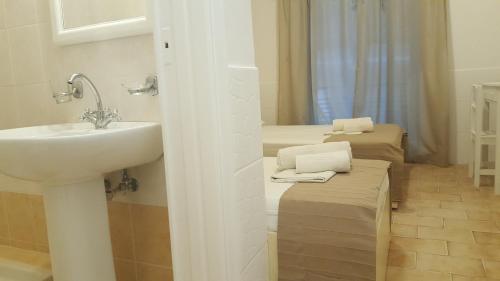 a bathroom with a sink and a mirror with two beds at Enalio Rooms in Glida