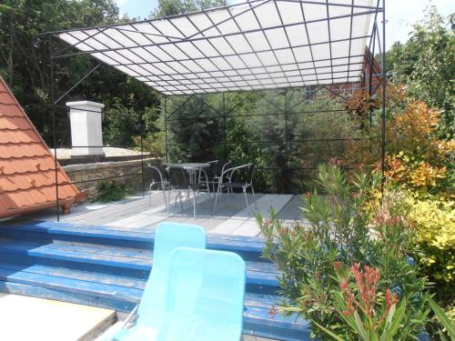 eine Terrasse mit Stühlen und einem Tisch im Garten in der Unterkunft Hegyestű Apartman in Monoszló