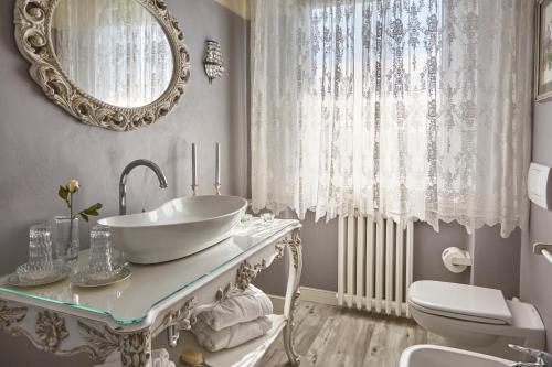 La salle de bains est pourvue d'un lavabo, de toilettes et d'un miroir. dans l'établissement La Zarabba Boutique Hotel, à Ponti sul Mincio