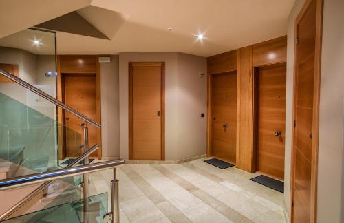 un couloir avec des portes en bois et un escalier en verre dans l'établissement Miracielos, à Barro de Llanes