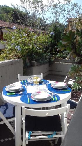 マリーナ・ディ・マッサにあるSunny seaside apartamentの白いテーブル(皿、皿付)