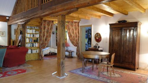 Una sala de estar con una mesa de madera y un sofá. en GÎTE EMERAUDE, en Plaine