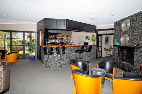 a bar with yellow chairs and a counter at Lincoln Downs Resort Batemans Bay in Batemans Bay