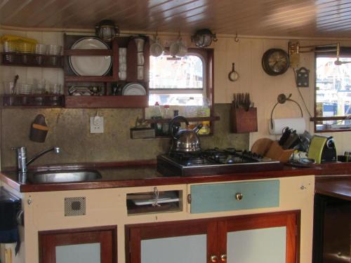 a kitchen with a sink and a stove at Zeilschip Fortuna in Medemblik