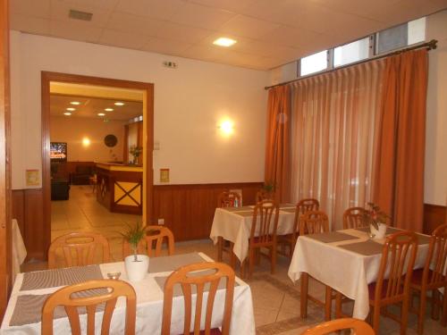 a dining room with tables and chairs and a window at Hotel Admitos in Volos