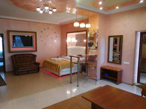 a bedroom with a bed and a table in a room at ApartHotel Dom in Odesa