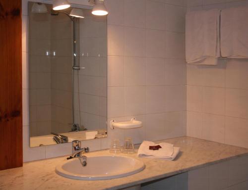 a bathroom with a sink and a mirror at Hostal La Catalana in Sant Llorenc de Morunys