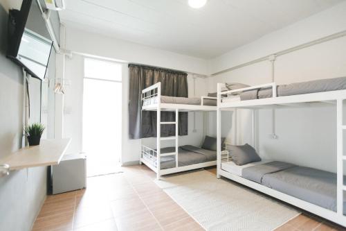 a room with two bunk beds and a desk at POSH 41 in Salaya