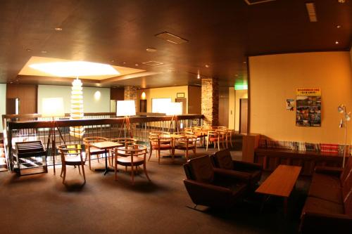 a restaurant with chairs and tables and a bar at Kashimayari Sports Village in Omachi