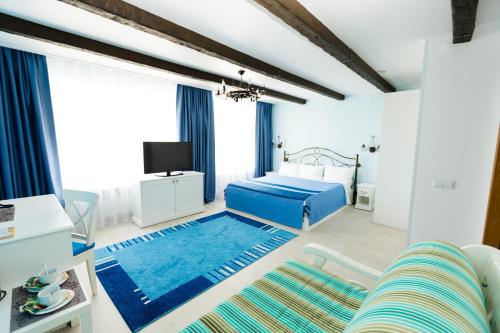 een slaapkamer met een blauw bed en een blauw tapijt bij Vorobyovy Gory Hotel in Kurgan