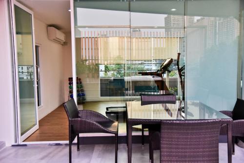 a dining room with a glass table and chairs at The Kaze 34 Hotel and Serviced Residence in Bangkok
