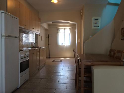 a kitchen with a table and a white refrigerator at Serifos Palace in Livadakia