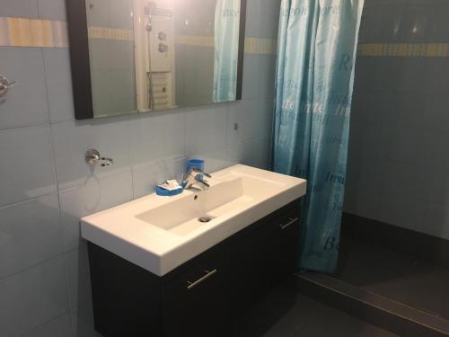 a bathroom with a white sink and a mirror at Serifos Palace in Livadakia