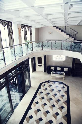 a large room with a staircase and a rug at Salut Hotel Almaty in Almaty