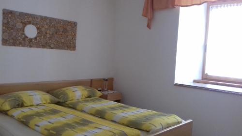 Apartment Norma في بوفيك: غرفة نوم بسرير ومخدات صفراء ونافذة