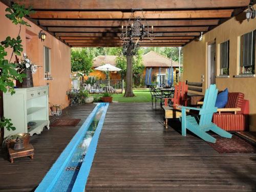 a wooden deck with benches and tables on a house at Love & Lemons in Yesod Hamaala