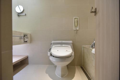 a bathroom with a toilet and a sink and a mirror at Pacific Hotel in Seoul