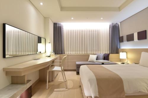 a hotel room with a bed and a desk at Pacific Hotel in Seoul