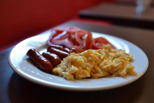 a plate of food with sausage and tomatoes on a table at Pension Falconi in Kolín