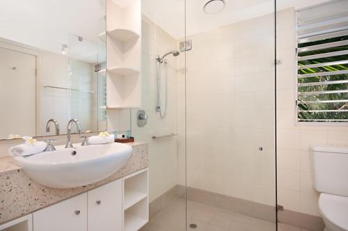 a white bathroom with a sink and a shower at 5231 BEACH CLUB PENTHOUSE in Palm Cove