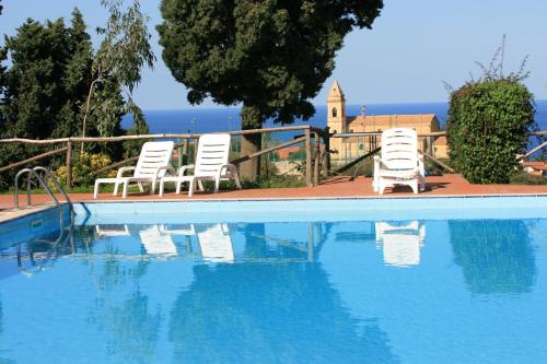 two chairs and a swimming pool with blue water at Agriturismo Ruralia in Santa Domenica